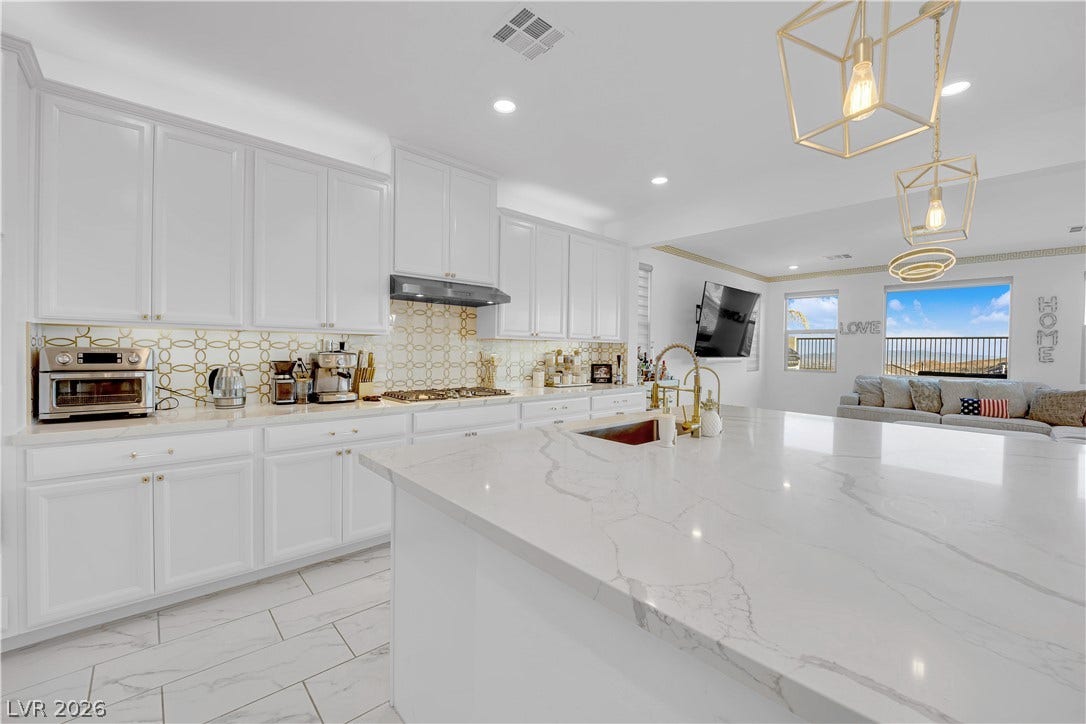 12415 Aster Hills Avenue, Las Vegas, NV 89138 Polished stone countertops and clean cabinetry anchor this open-concept culinary space.