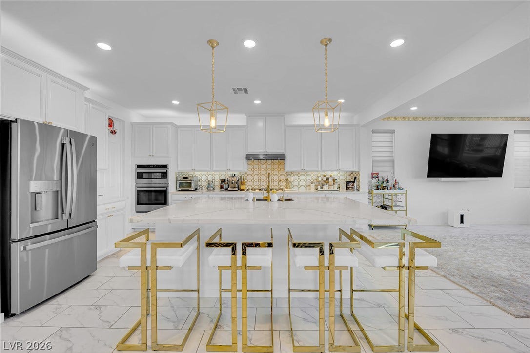 12415 Aster Hills Avenue, Las Vegas, NV 89138 Gleaming stone tile flooring and custom cabinetry define this modern open-concept culinary space.