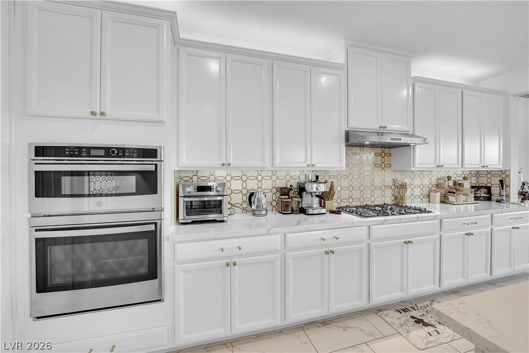 12415 Aster Hills Avenue, Las Vegas, NV 89138 Gleaming stone countertops and matching cabinetry maximize storage and preparation space in this kitchen.