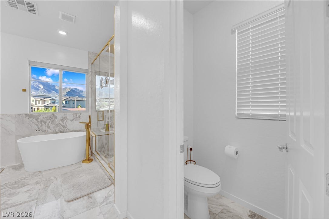 12415 Aster Hills Avenue, Las Vegas, NV 89138 Marble flooring and a freestanding tub pair beautifully with scenic mountain views.