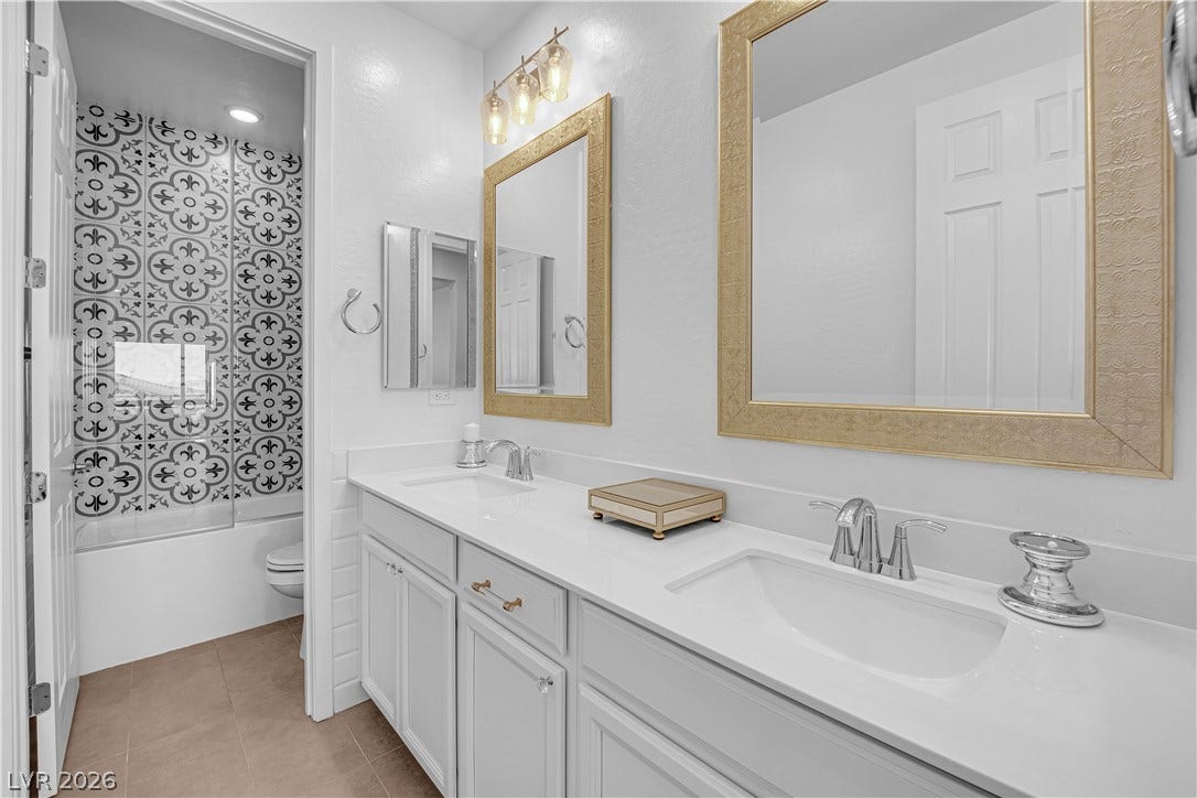 12415 Aster Hills Avenue, Las Vegas, NV 89138 Gleaming surfaces and custom tile work elevate this modern dual-vanity washroom.
