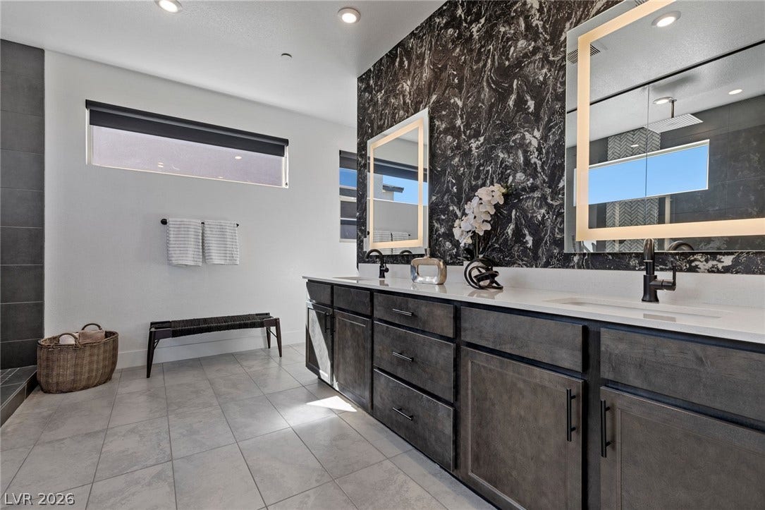 1976 Peaceful Mesa Court, Henderson, NV 89052 A long double vanity sits beneath patterned wall details and clean modern windows.