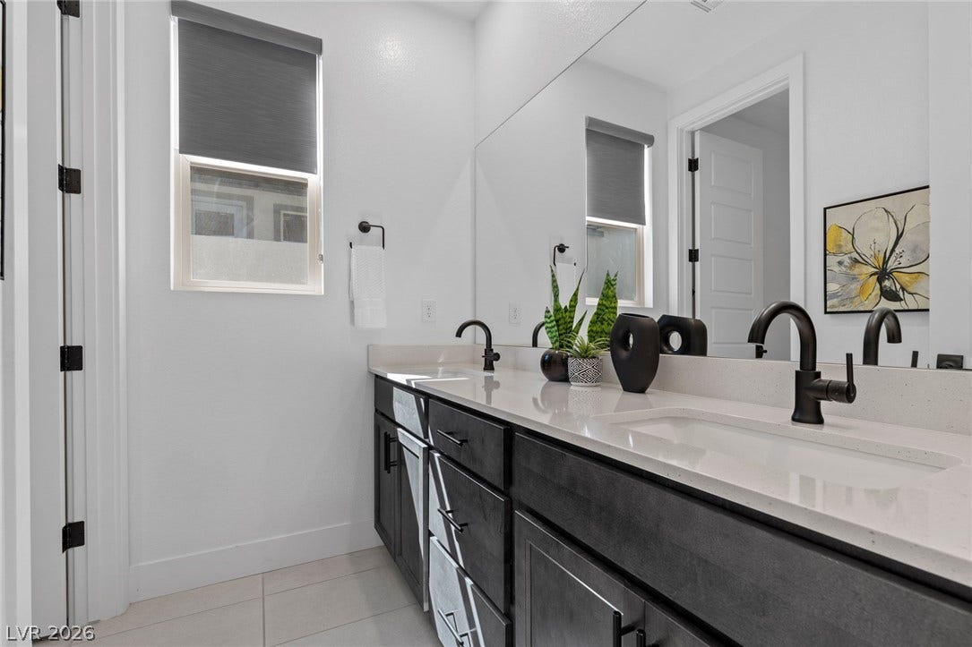 1976 Peaceful Mesa Court, Henderson, NV 89052 Crisp white walls surround a sleek double vanity topped with stone counters.