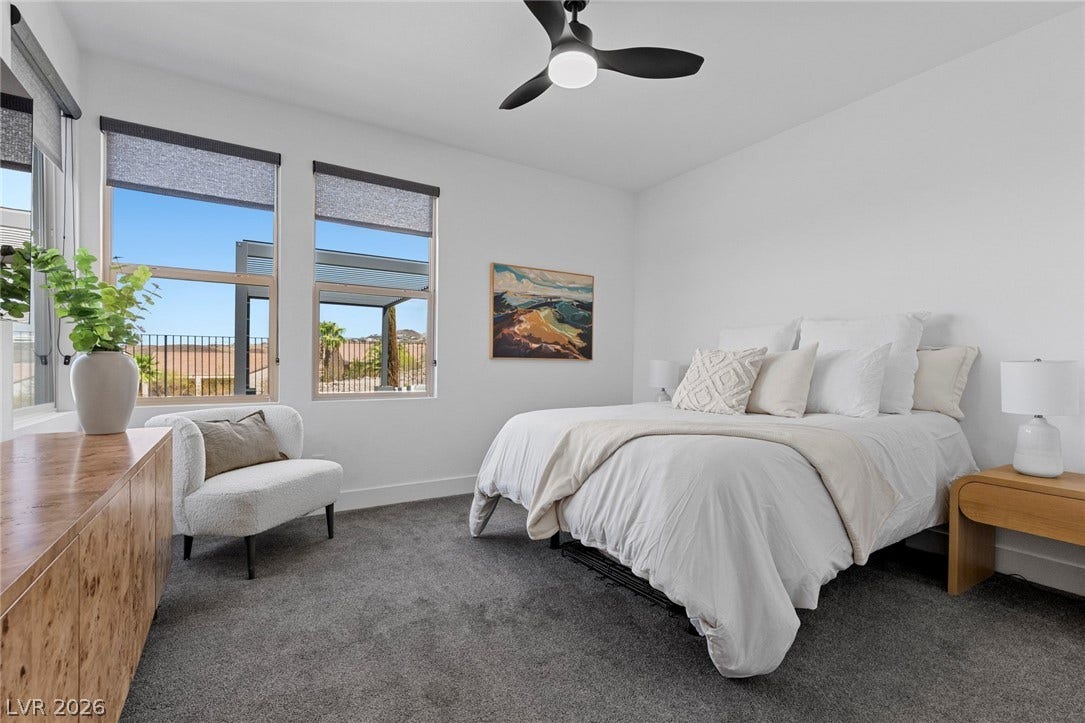1976 Peaceful Mesa Court, Henderson, NV 89052 A spacious bedroom offers plush carpeting and large windows frame peaceful neighborhood views.
