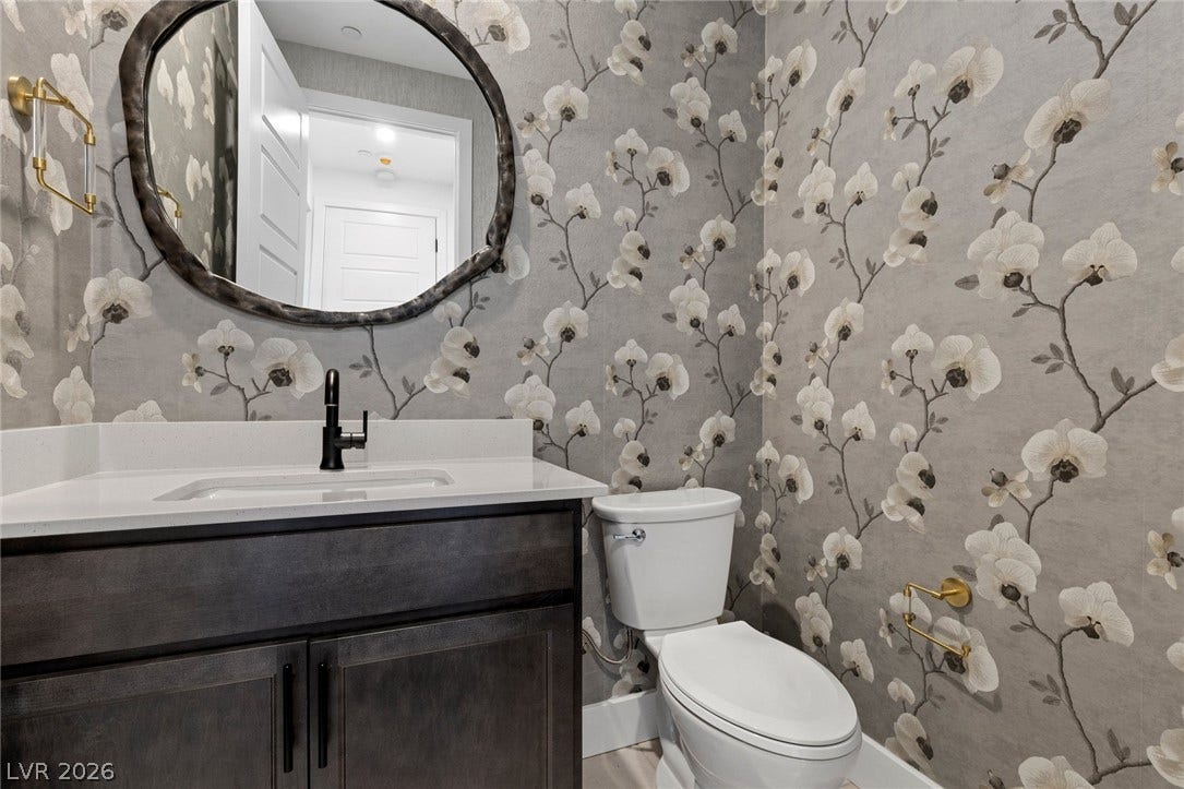 1976 Peaceful Mesa Court, Henderson, NV 89052 Floral wall coverings and a stone-topped vanity elevate this modern powder room.