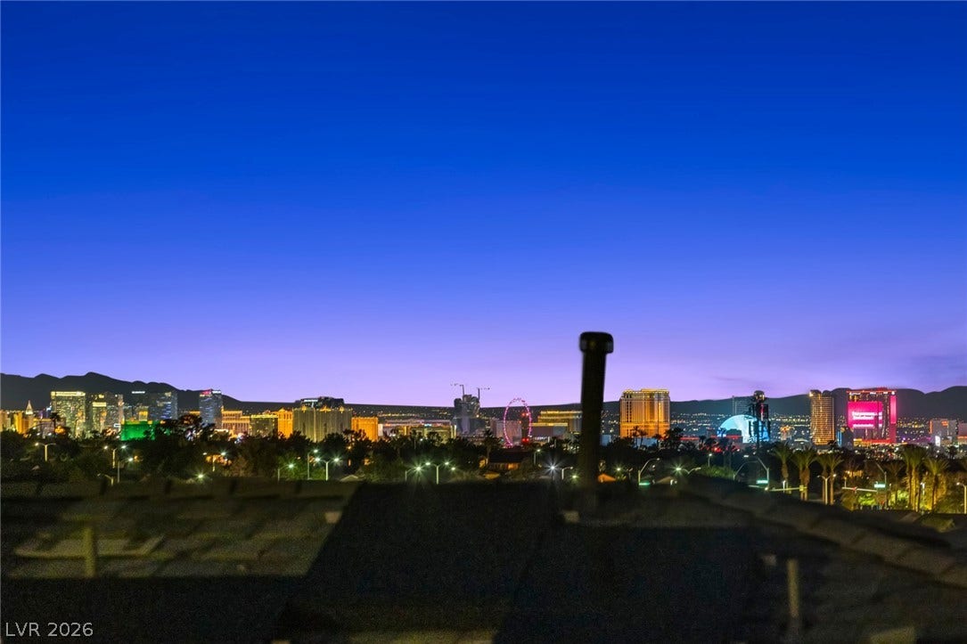 1976 Peaceful Mesa Court, Henderson, NV 89052 Glittering city lights decorate the horizon under a twilight sky.