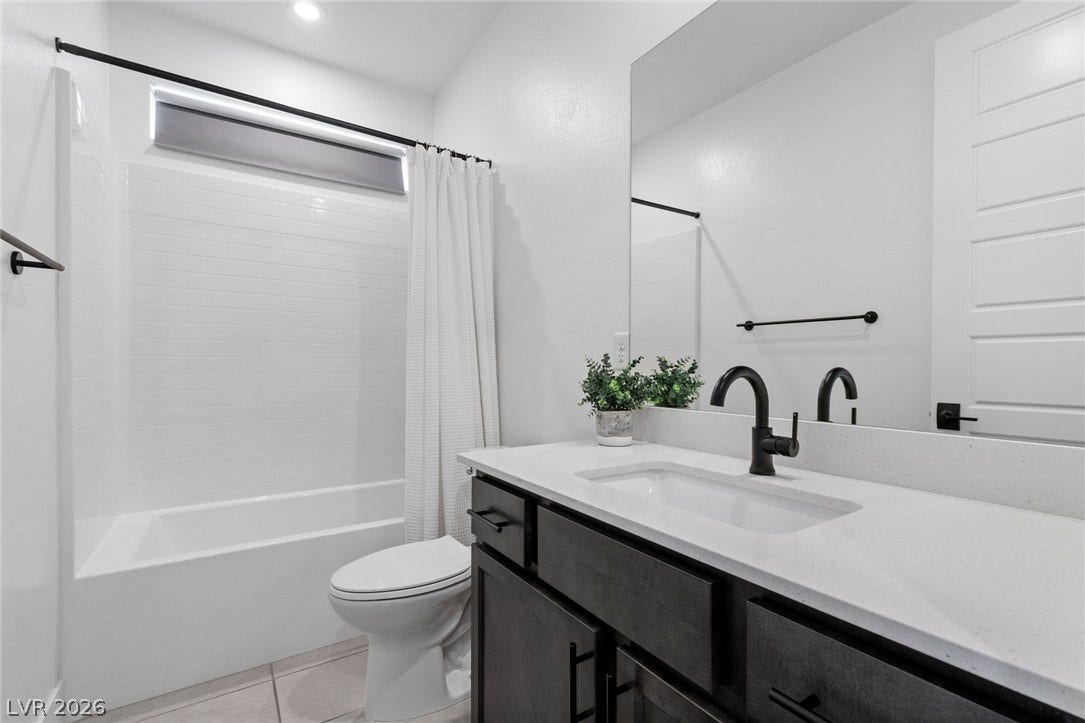 1976 Peaceful Mesa Court, Henderson, NV 89052 Modern finishes define this washroom featuring a dark vanity with a crisp white stone counter.