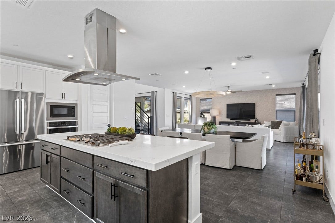 1976 Peaceful Mesa Court, Henderson, NV 89052 An open floorplan seamlessly connects the stone-countertop kitchen island with adjacent dining and living spaces.