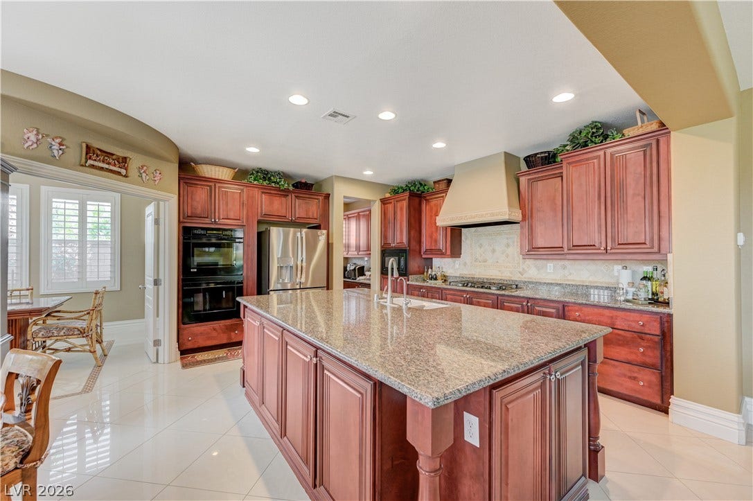 218 Crooked Putter Drive, Las Vegas, NV 89148 Gleaming polished tile floors anchor a chef kitchen finished with rich wood cabinetry.