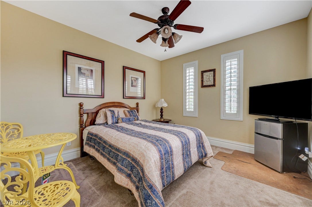 218 Crooked Putter Drive, Las Vegas, NV 89148 Warm neutral walls and carpeted flooring define this cozy sleeping space with plantation shutters.