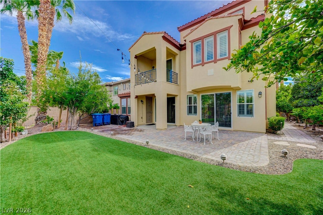 218 Crooked Putter Drive, Las Vegas, NV 89148 A spacious paved patio and manicured green lawn highlight this inviting outdoor retreat.