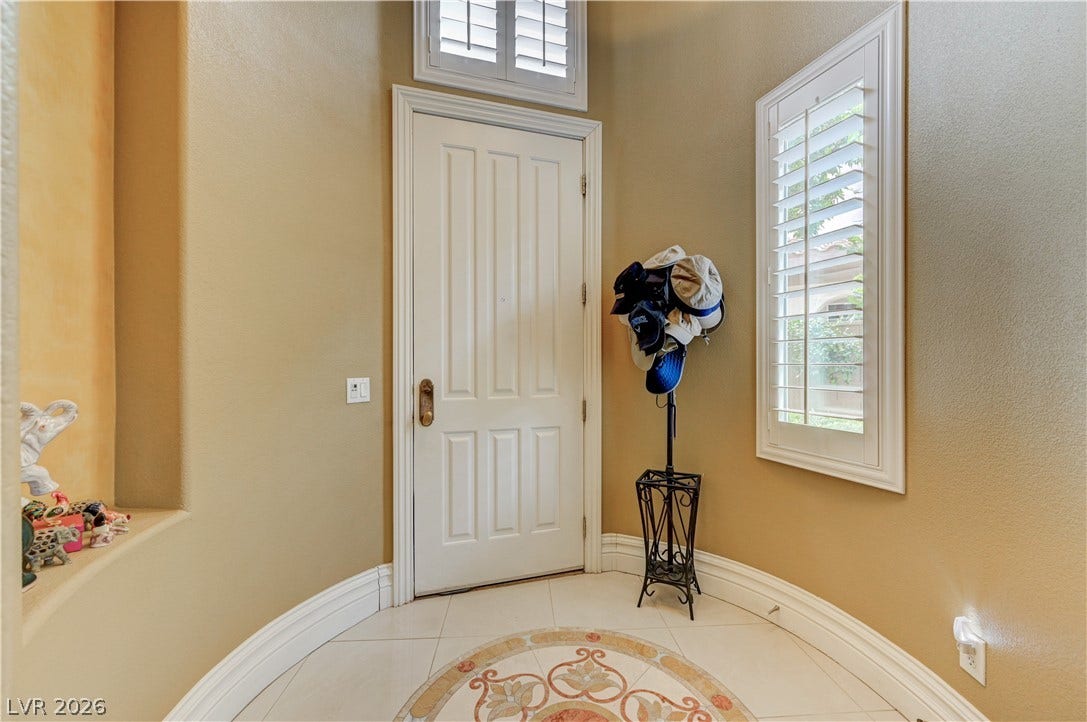 218 Crooked Putter Drive, Las Vegas, NV 89148 High ceilings and plantation shutters welcome guests into this elegant tiled entry foyer.