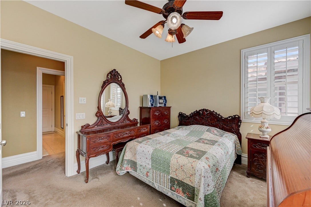 218 Crooked Putter Drive, Las Vegas, NV 89148 An inviting bedroom features plush carpeting, a large window with shutters, and crown molding details.