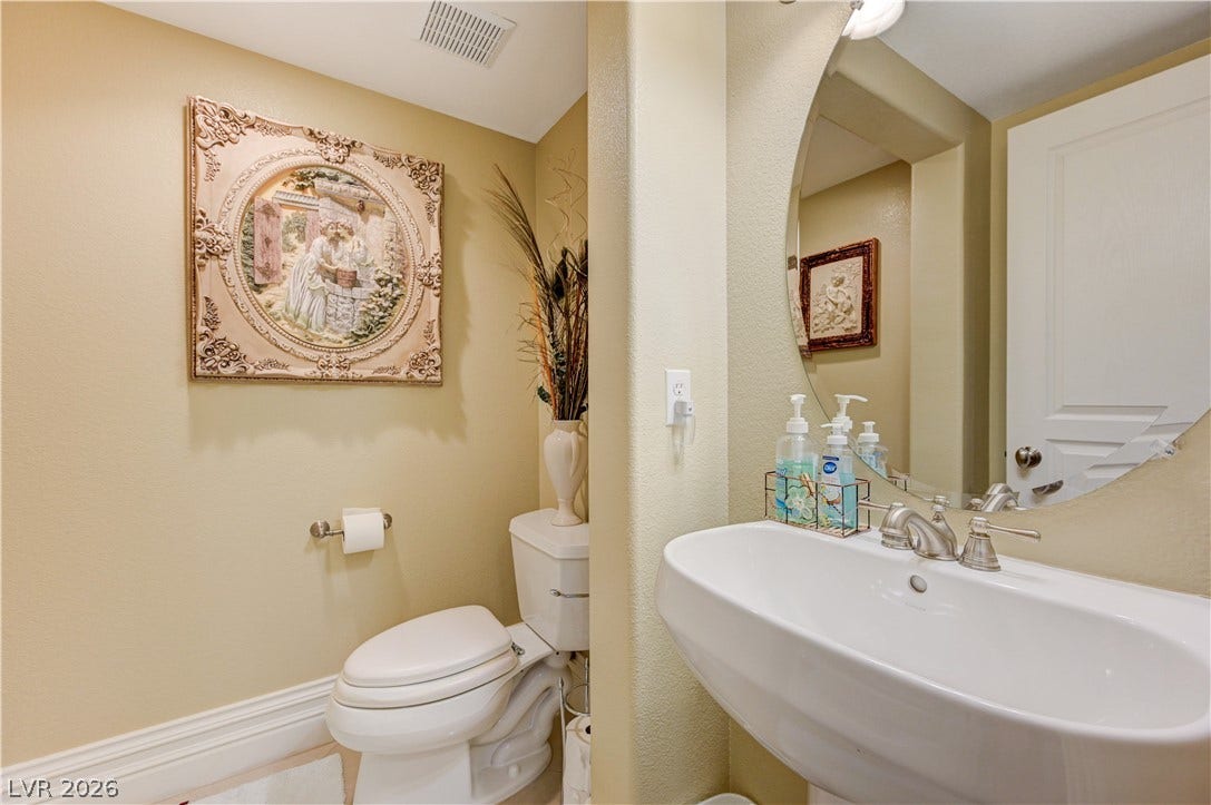 218 Crooked Putter Drive, Las Vegas, NV 89148 An elegant powder room features a pedestal sink and classic crown molding details.