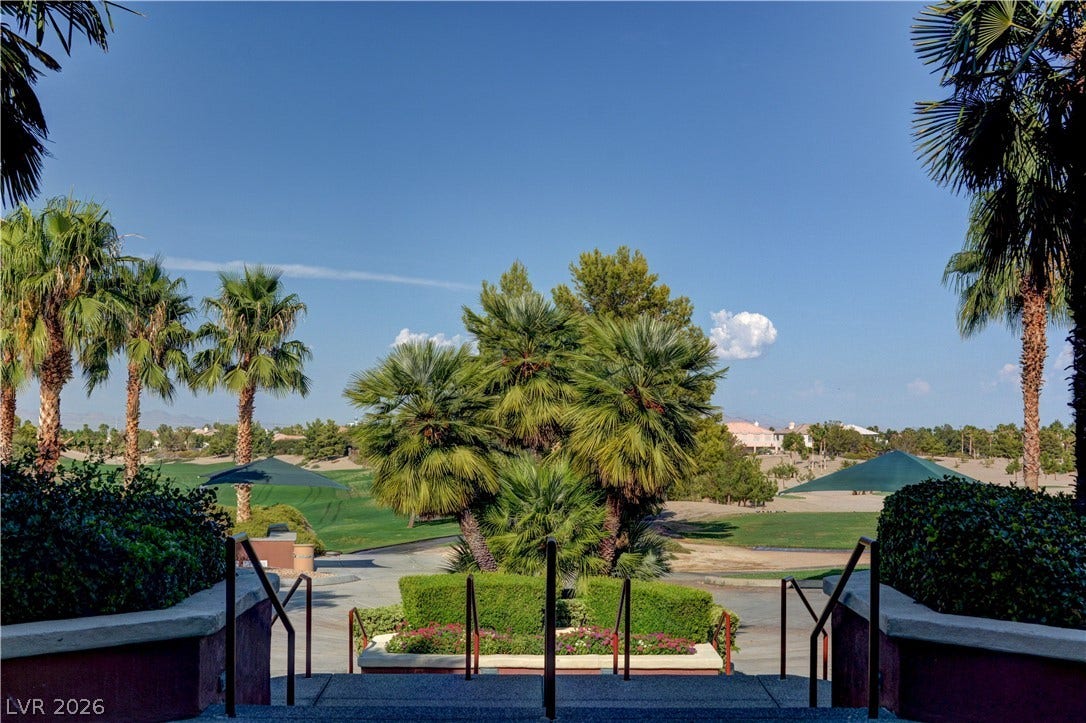 218 Crooked Putter Drive, Las Vegas, NV 89148 Stone steps lead toward manicured greenery and scenic golf course views framed by palm trees.