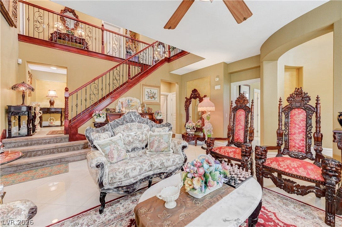 218 Crooked Putter Drive, Las Vegas, NV 89148 Polished tile flooring and an elegant wooden staircase define this soaring double-height living area.