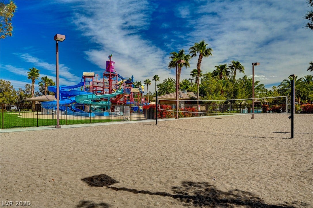218 Crooked Putter Drive, Las Vegas, NV 89148 An outdoor sand volleyball court sits adjacent to a vibrant water park play structure.