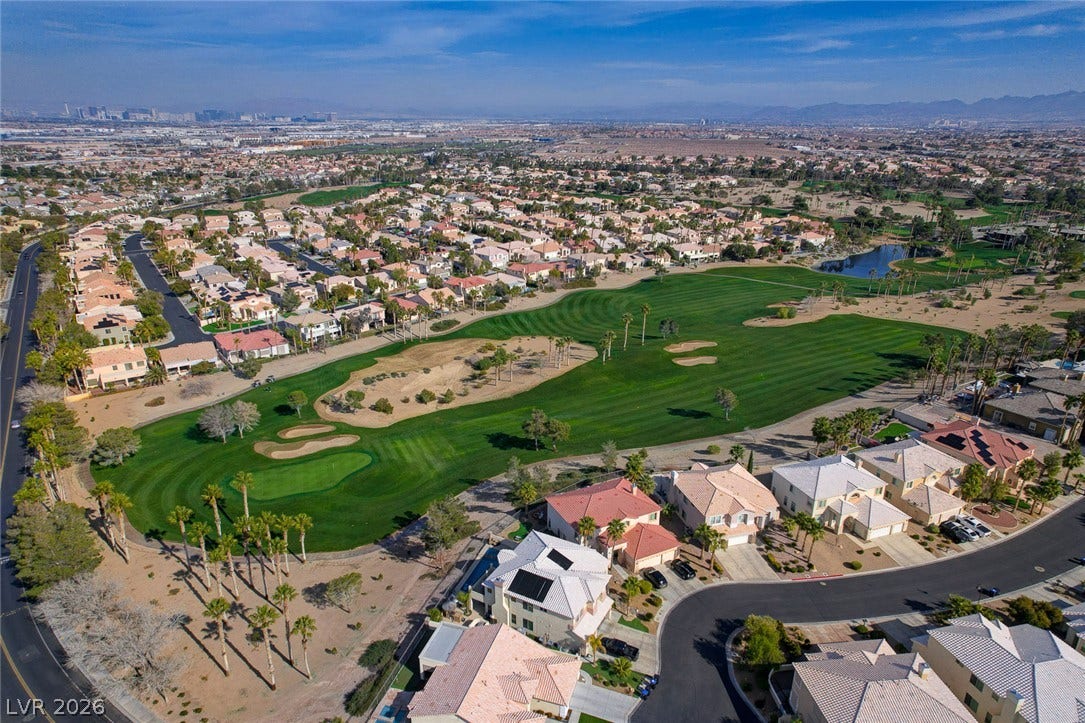 218 Crooked Putter Drive, Las Vegas, NV 89148 An aerial perspective showcases a manicured green fairway weaving through an established residential neighborhood.