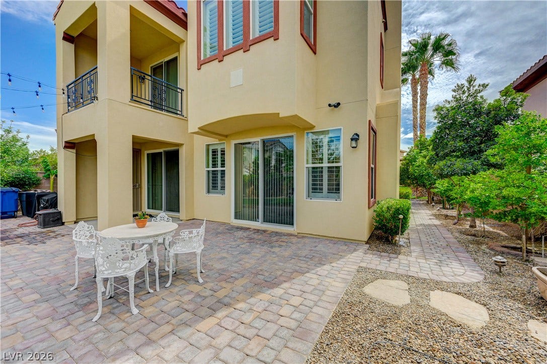 218 Crooked Putter Drive, Las Vegas, NV 89148 A spacious paved patio adjoins the stucco exterior, offering quiet outdoor living space.