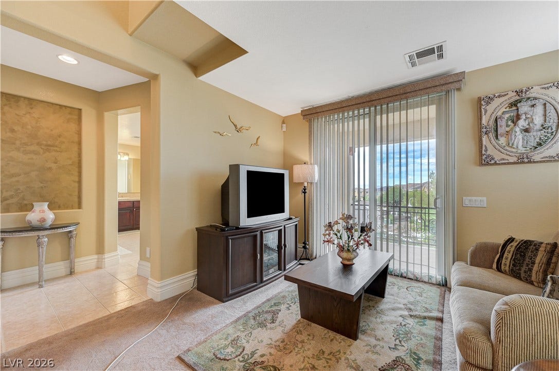 218 Crooked Putter Drive, Las Vegas, NV 89148 Sliding glass doors open to a private balcony in this comfortable main living space.