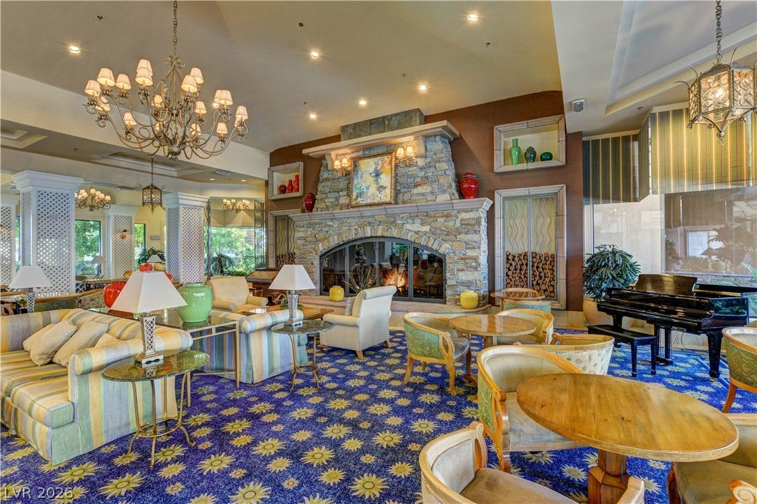 218 Crooked Putter Drive, Las Vegas, NV 89148 A grand stone fireplace anchors this expansive lounge area highlighted by elegant chandeliers.