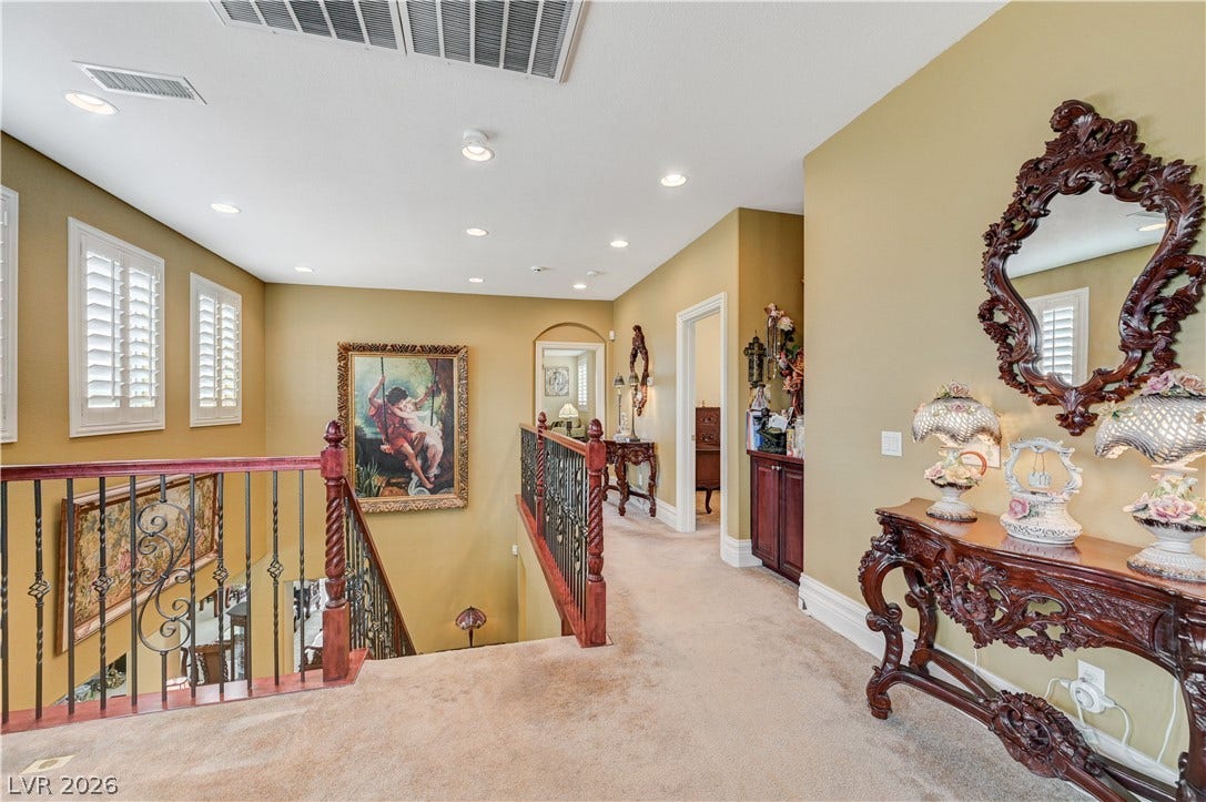 218 Crooked Putter Drive, Las Vegas, NV 89148 An upper landing boasts recessed lighting, plush carpeting, and elegant wrought iron railings.