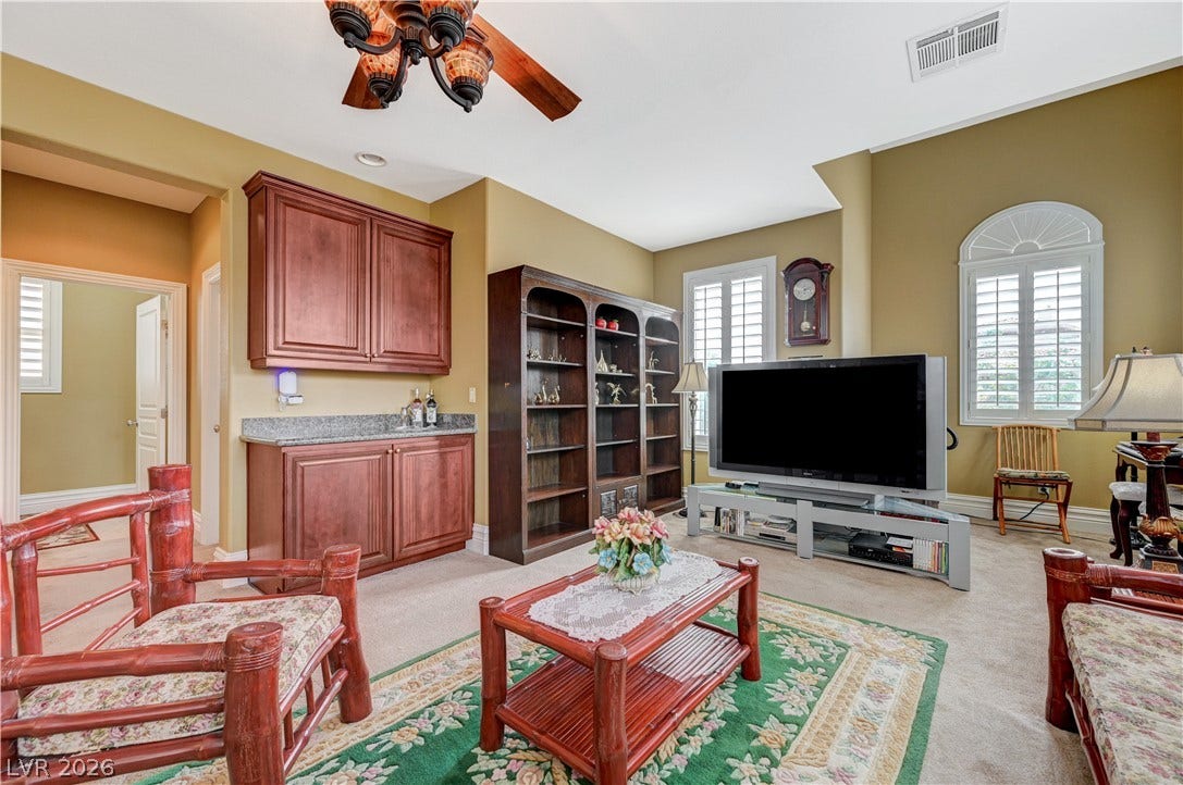 218 Crooked Putter Drive, Las Vegas, NV 89148 Built-in cabinets, tall arched windows, and soft carpeting define this comfortable gathering space.
