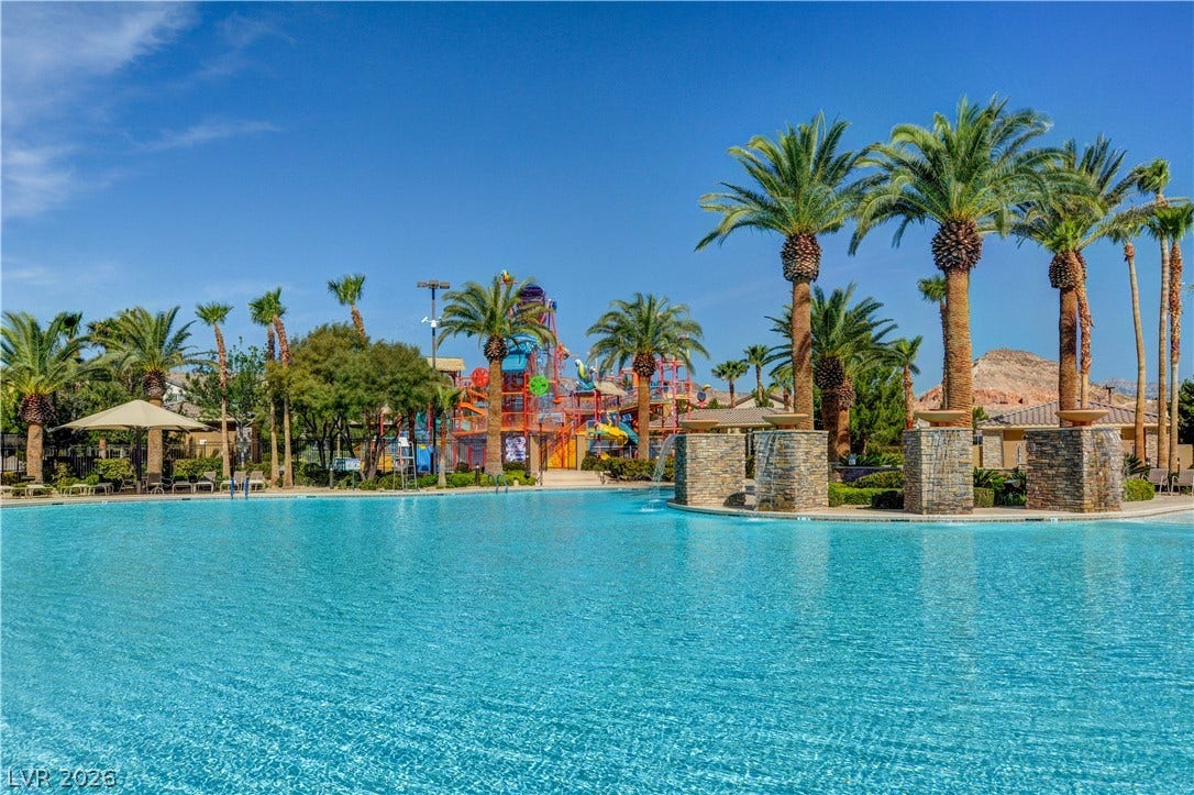 218 Crooked Putter Drive, Las Vegas, NV 89148 An expansive community swimming pool is surrounded by towering palm trees and stone water features.