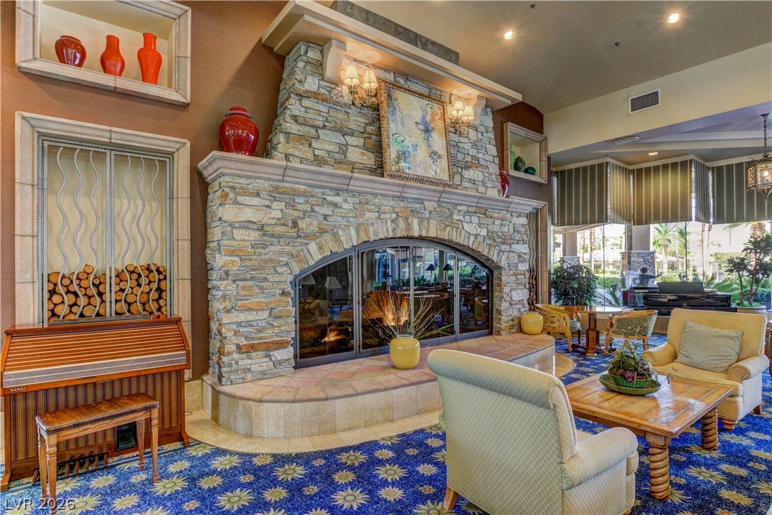 218 Crooked Putter Drive, Las Vegas, NV 89148 An imposing stone fireplace anchors this spacious lounge featuring expansive windows and high ceilings.
