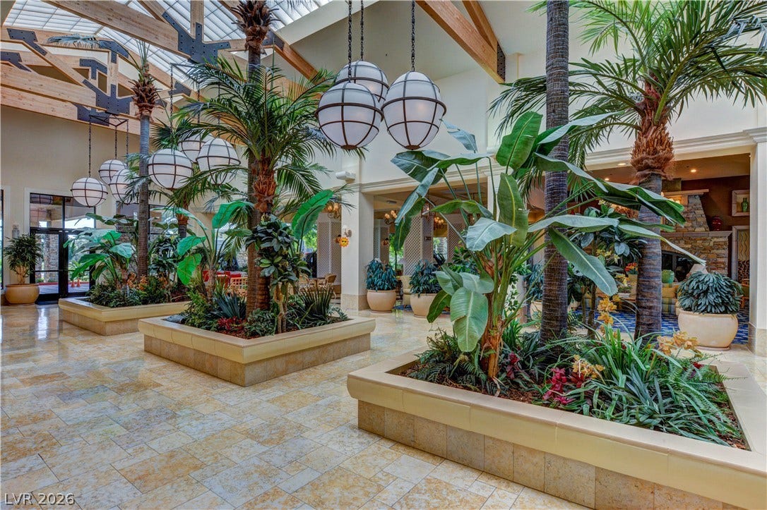 218 Crooked Putter Drive, Las Vegas, NV 89148 Soaring beamed ceilings and skylights illuminate a grand indoor garden with stone tile flooring.