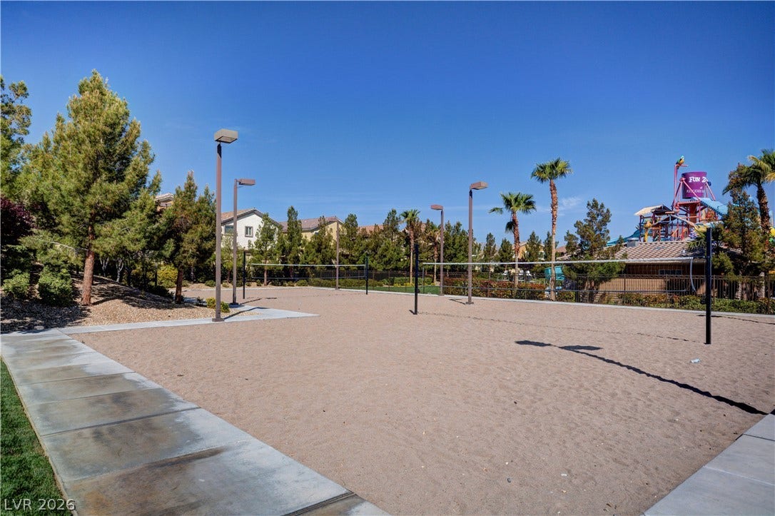 218 Crooked Putter Drive, Las Vegas, NV 89148 A spacious outdoor sand volleyball court is illuminated by tall area lighting.