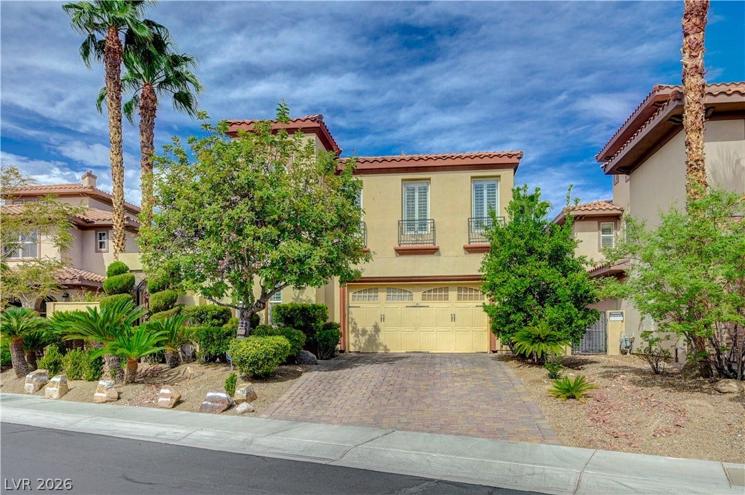 218 Crooked Putter Drive, Las Vegas, NV 89148 Mediterranean-inspired architecture highlights this multi-level exterior complete with tile roofing and manicured desert landscaping.