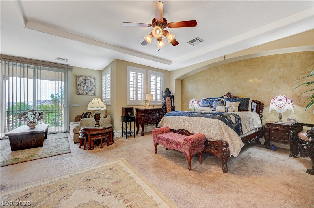 218 Crooked Putter Drive, Las Vegas, NV 89148 Plentiful natural light fills a bedroom featuring a tray ceiling and sliding glass doors.