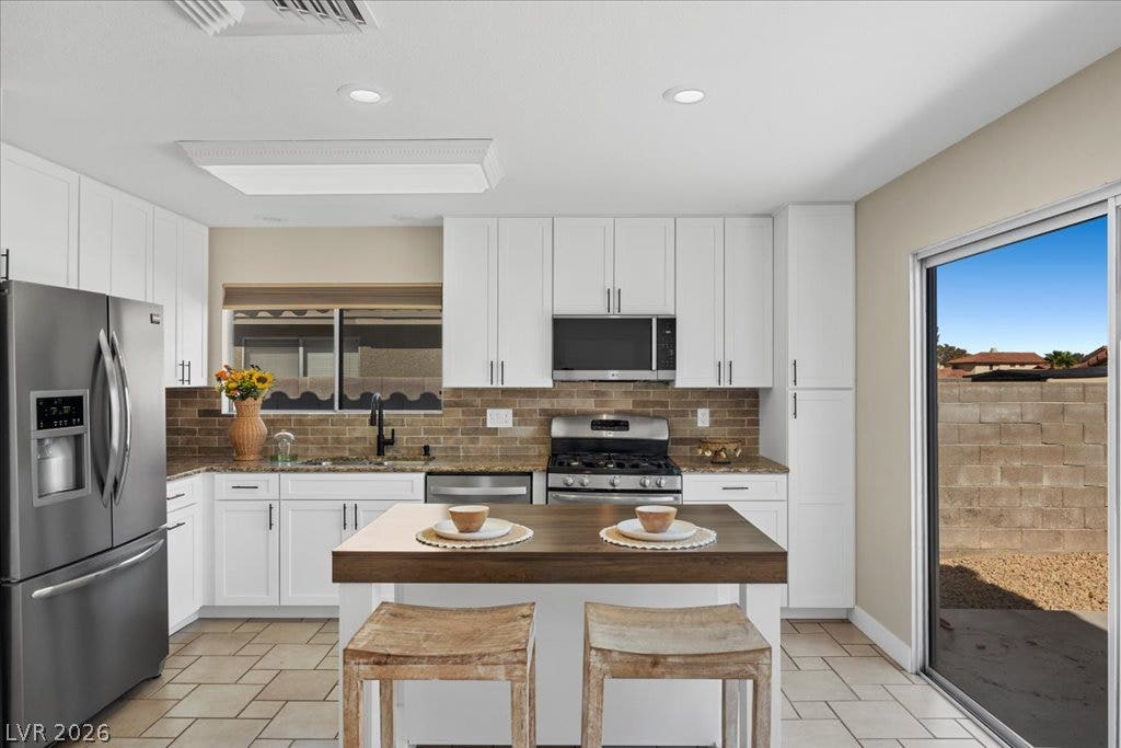 2432 Millcroft Drive, Henderson, NV 89074 Gleaming granite countertops and a floating island anchor this modernized cooking space.