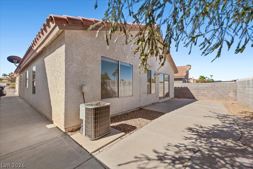 2432 Millcroft Drive, Henderson, NV 89074 Concrete walkways border the exterior stucco walls beneath a classic tile roof.
