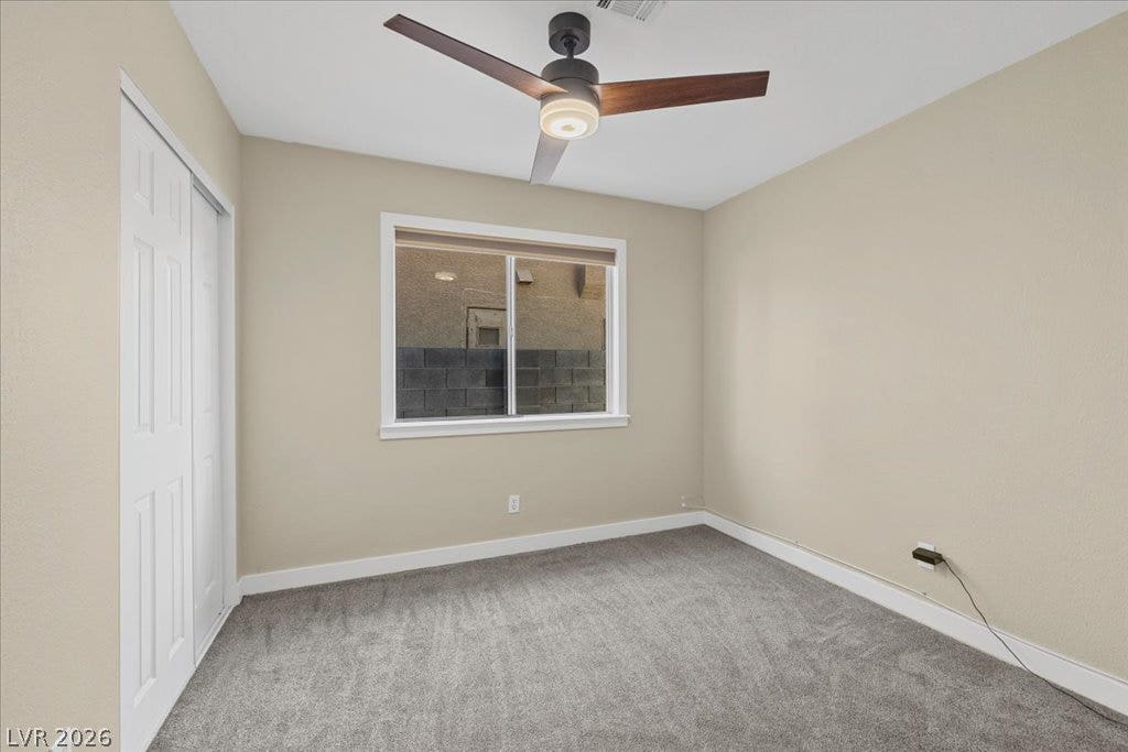 2432 Millcroft Drive, Henderson, NV 89074 Soft carpeting pairs with a wide window overlooking the yard inside this comfortable bedroom.