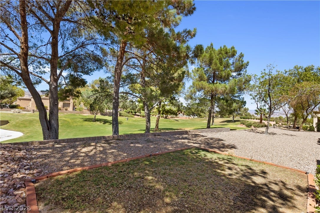 Mature trees frame beautiful golf course views from this low-maintenance yard.