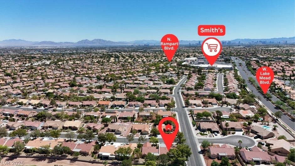 Aerial view showcasing the suburban neighborhood layout surrounded by distant mountain ranges.