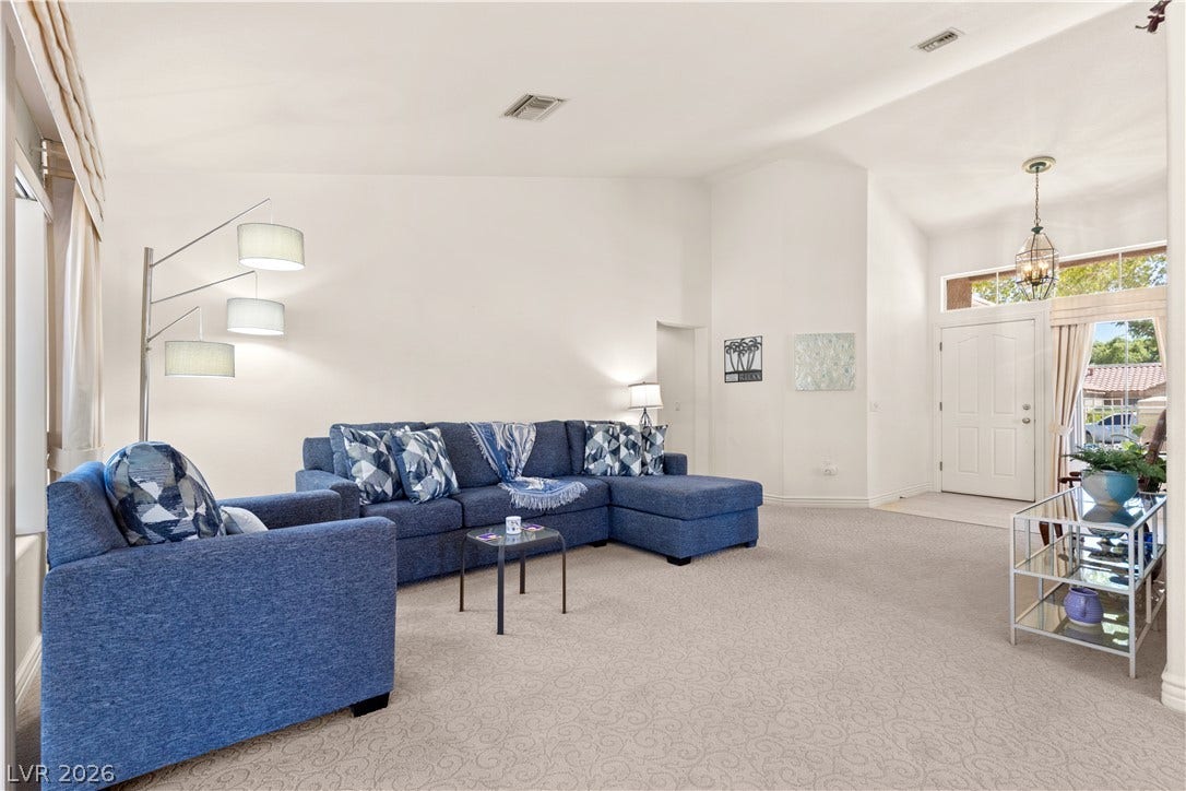 Vaulted ceilings and soft carpeting create an inviting atmosphere in this airy living space.