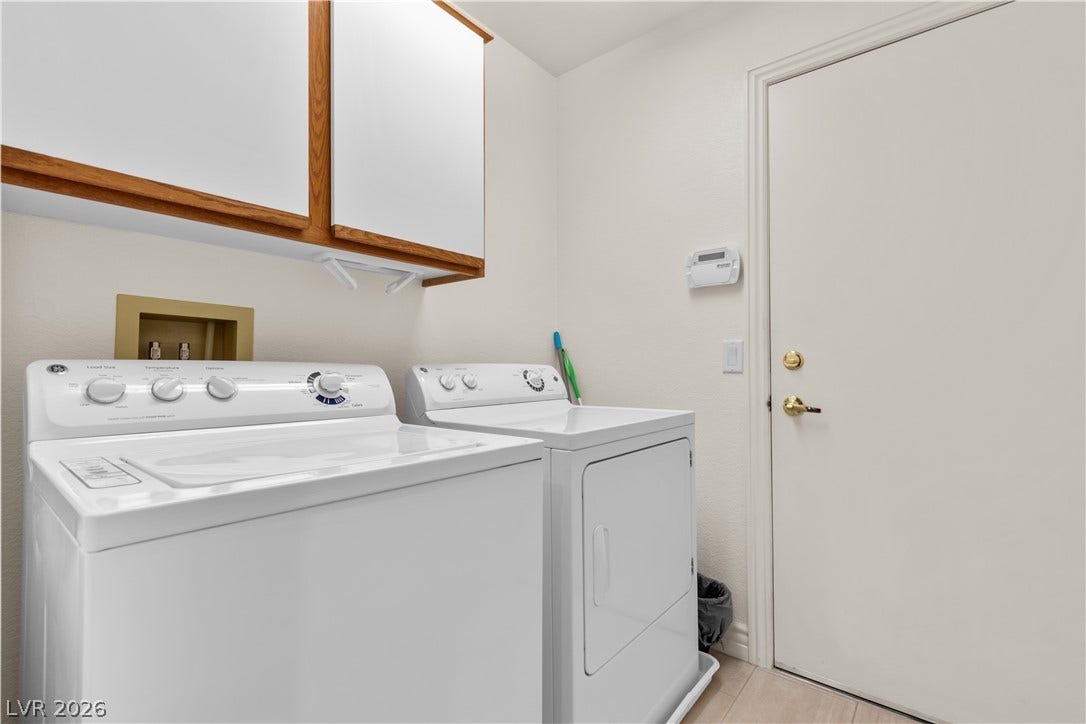 Functional utility space features overhead cabinetry and direct exterior or garage access.