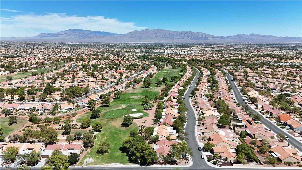 A golf course community winds through the neighborhood with mountains framing the distant horizon.