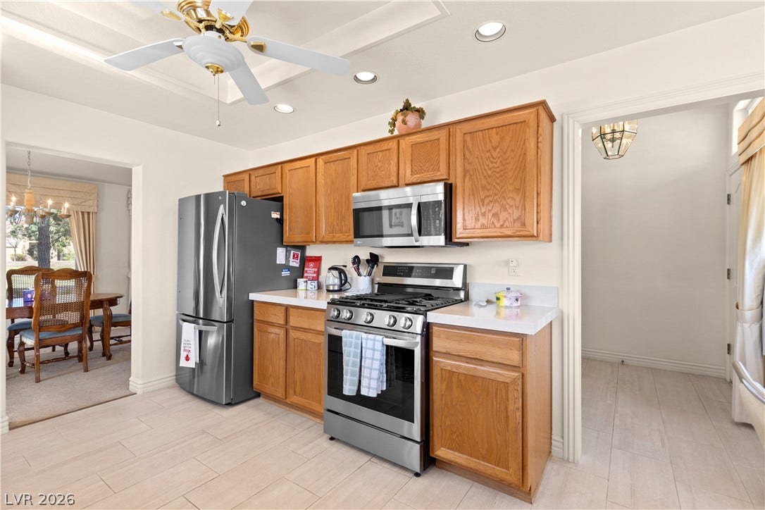 Warm oak cabinetry pairs with light tile flooring in this classic kitchen layout.
