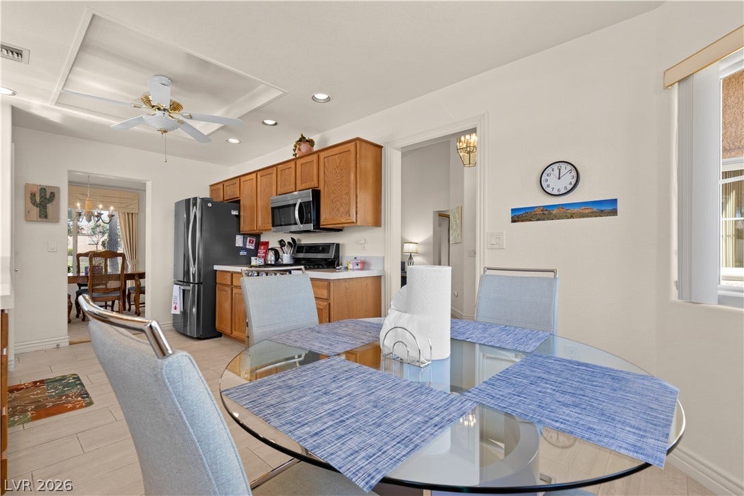 An inviting dining area flows seamlessly into the kitchen under recessed lighting.