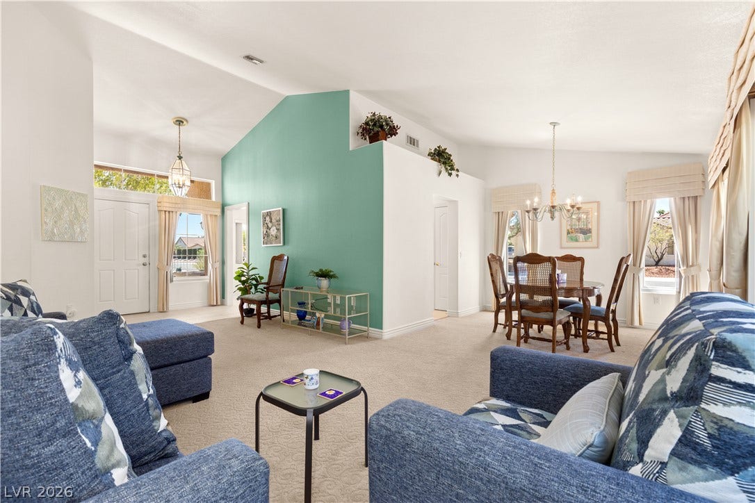 Vaulted ceilings and soft carpeting define this open-concept main living and dining zone.