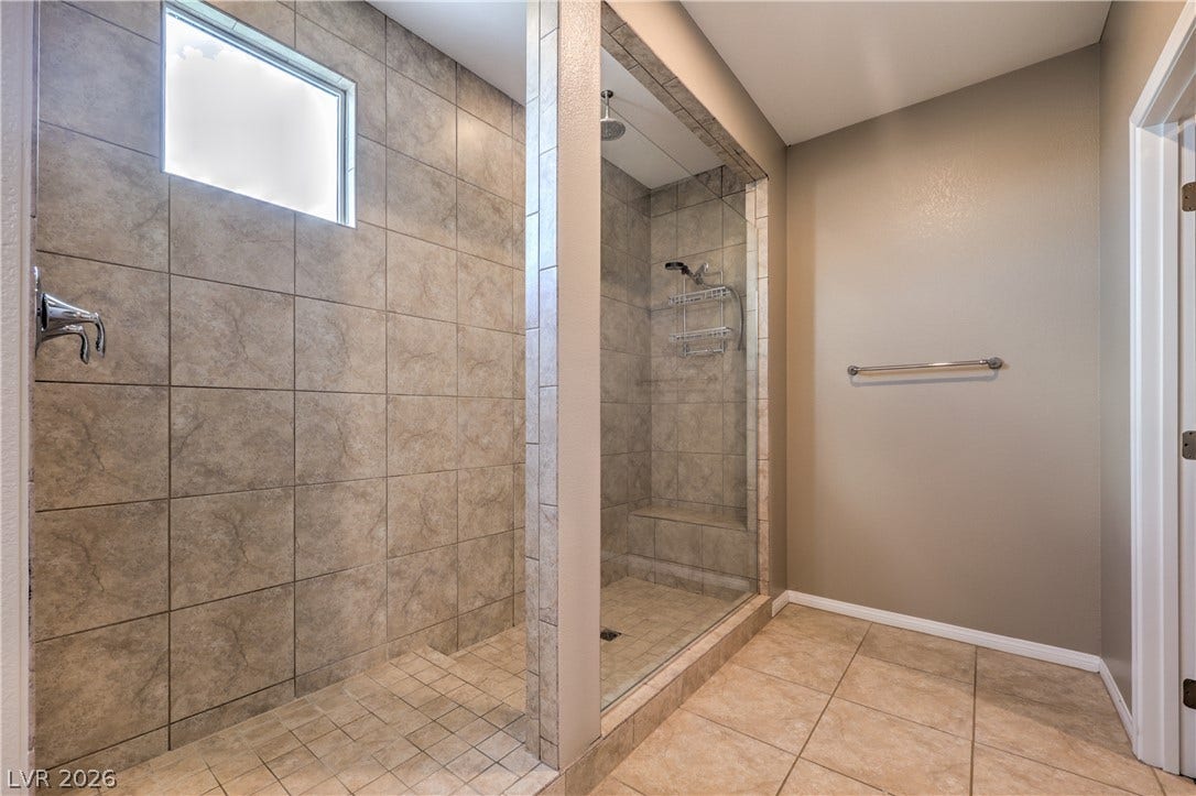 4658 Chestnut Tiger Street, North Las Vegas, NV 89031 Floor-to-ceiling tiling defines this spacious walkthrough shower enclosure with a built-in bench.