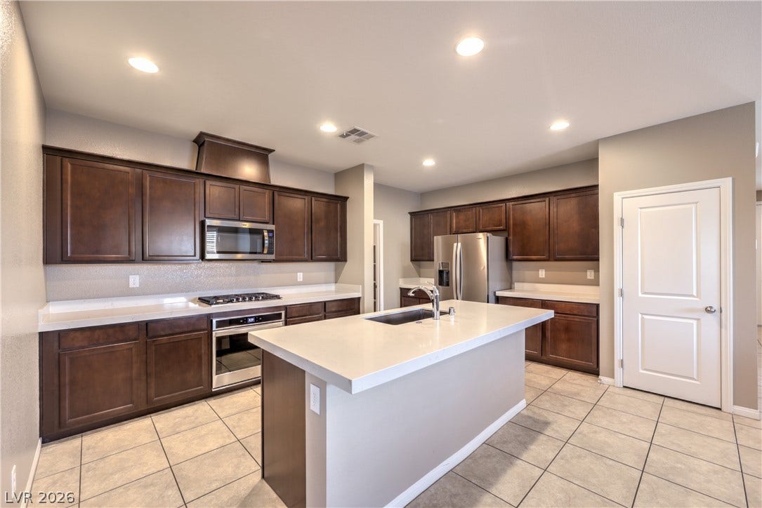 4658 Chestnut Tiger Street, North Las Vegas, NV 89031 Rich wood cabinetry contrasts beautifully with pale countertops and tile floors in this kitchen.