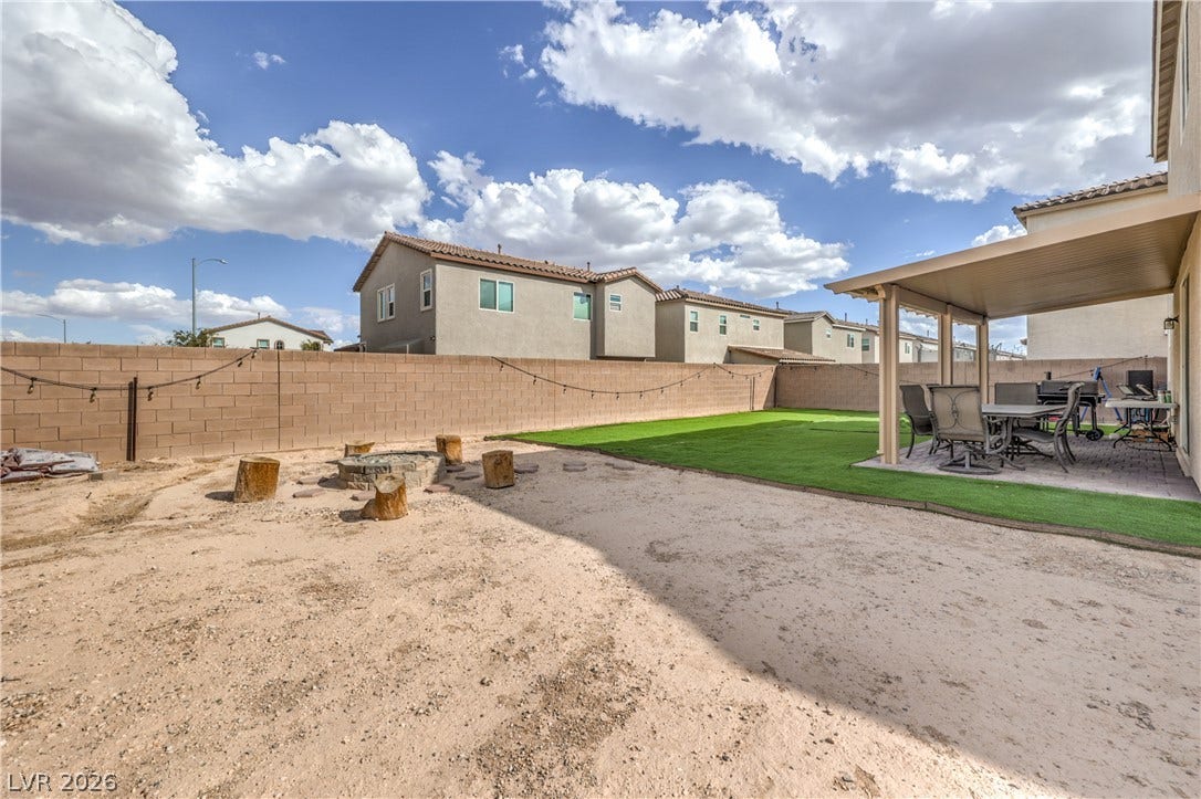 4658 Chestnut Tiger Street, North Las Vegas, NV 89031 An enclosed backyard features a covered patio and a built-in fire pit area.