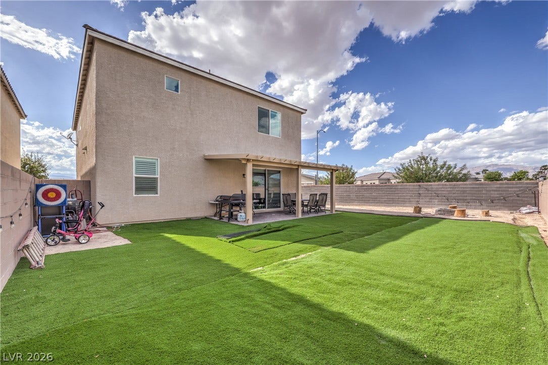 4658 Chestnut Tiger Street, North Las Vegas, NV 89031 Green turf and a covered patio define this low-maintenance backyard retreat under open skies.