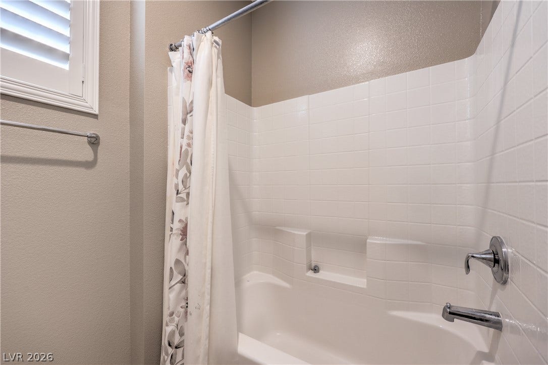 4658 Chestnut Tiger Street, North Las Vegas, NV 89031 Clean tile surrounds the shower and tub combination in this functional bathroom space.