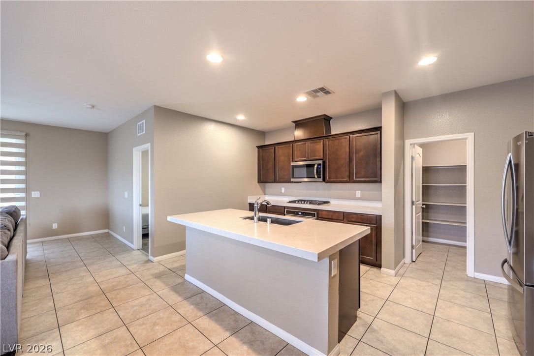 4658 Chestnut Tiger Street, North Las Vegas, NV 89031 Tiled flooring and recessed lighting accent the functional layout with a central island.